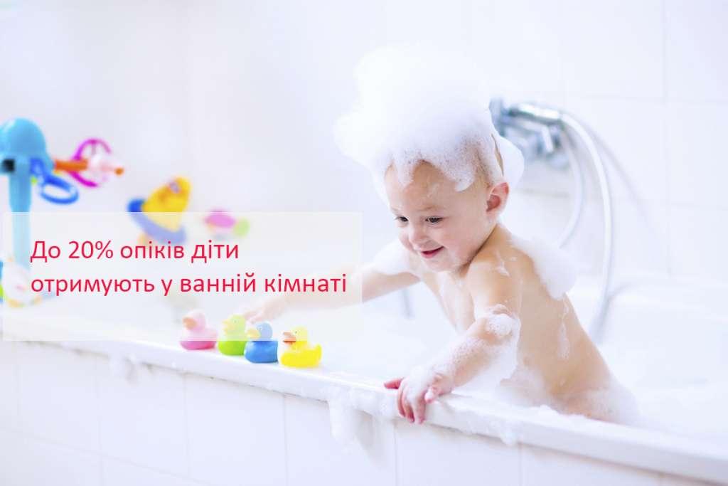 Cute little baby boy taking bath playing with foam and colorful rubber duck toys in a white sunny bathroom