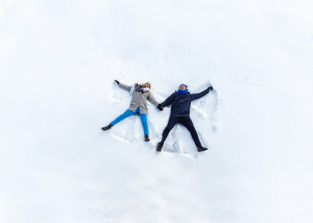 happy-young-couple-winter-park-lying-snow-making-snow-angel_132024-567