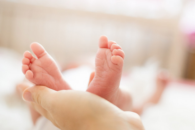 baby-feet-in-mother-hands-mom-and-her-child-happy-family-concept_98438-5
