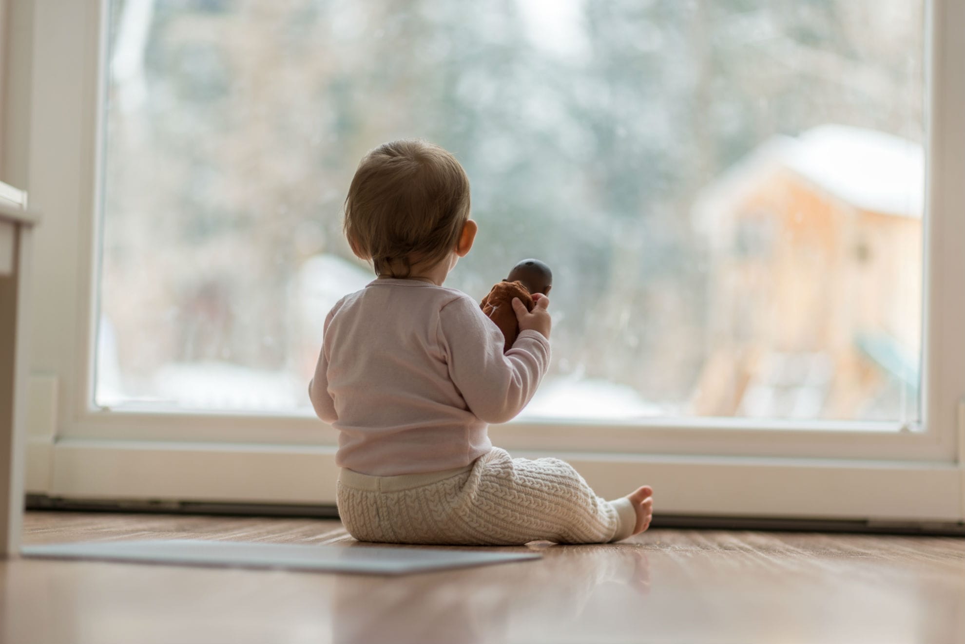 little-baby-girl-watching-the-snow-outdoors-SKCEN47-min