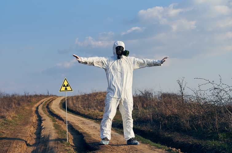 Environmentalist standing by ionizing radiation hazard symbol.
