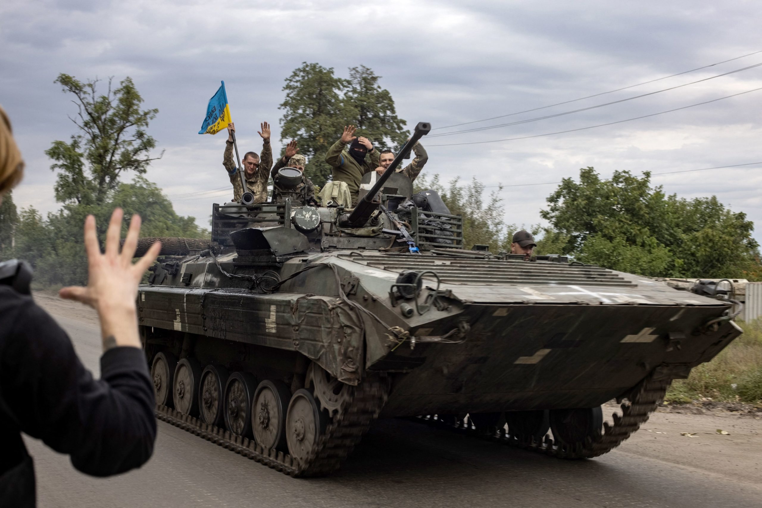 TOPSHOT &#8211; In this photograph taken on September 20, 2022 a local resident greets Ukrainian soldiers riding an armoured personnel carrier in Mala Komyshuvakha, near Izyum, Kharkiv region. (Photo by Yevhen TITOV / AFP) (Photo by YEVHEN TITOV/AFP via Getty Images)