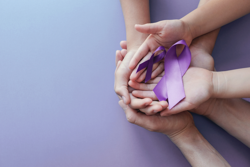 Adult and child hands holding purple ribbons, Alzheimer's diseas