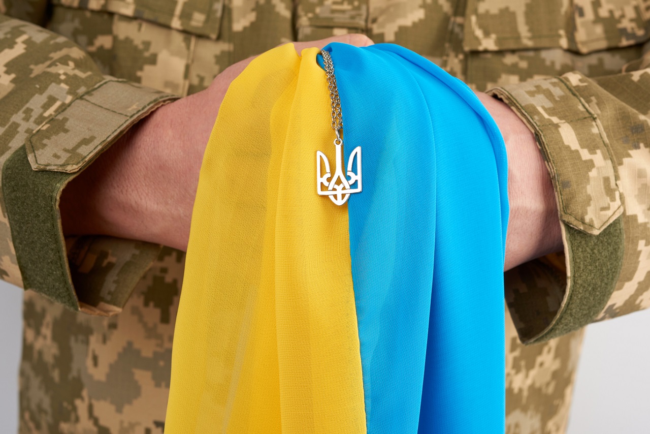 Ukrainian man warrior dressed in a military pixel uniform holds