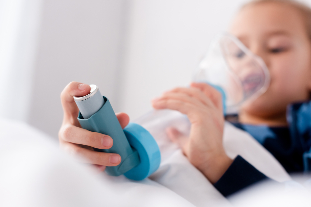 дівчинка з астмою користується інгалятором