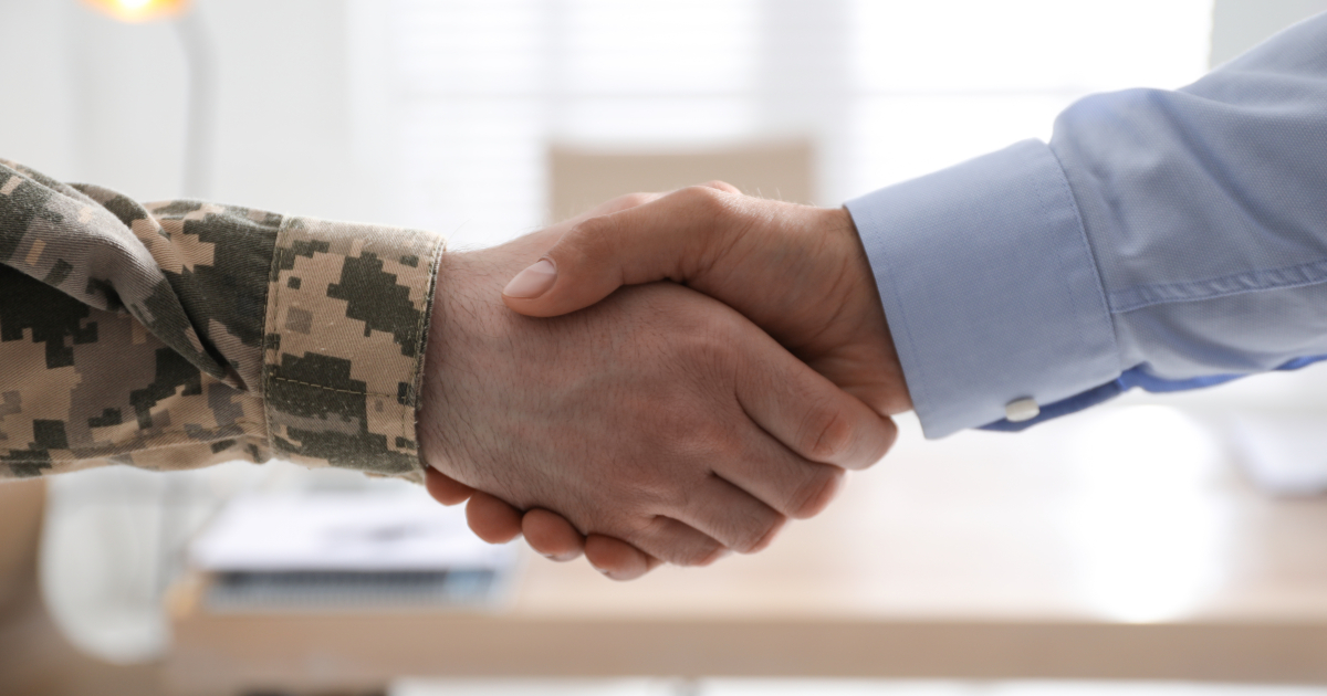 Soldier and businessman shaking hands indoors, closeup