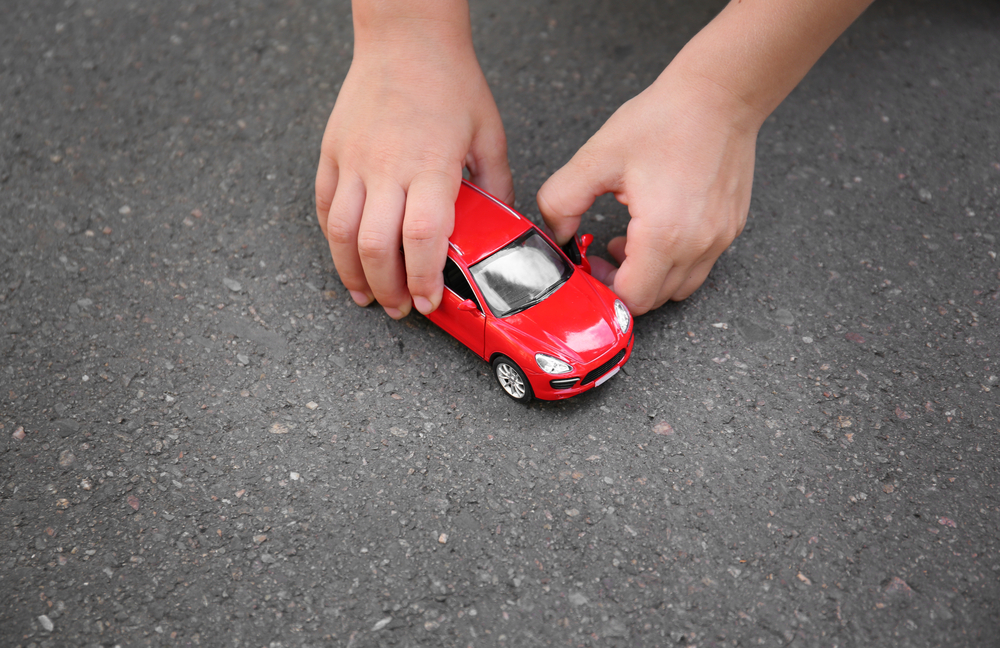 Little boy playing with toy car outdoor