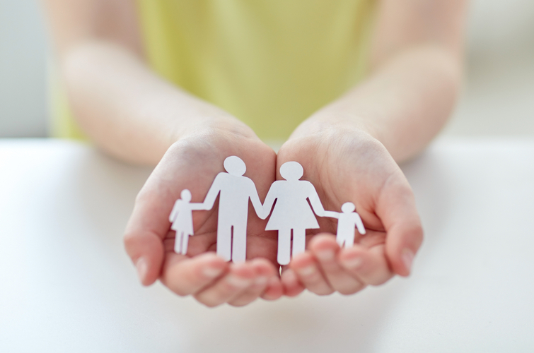 close up of child hands with paper family cutout