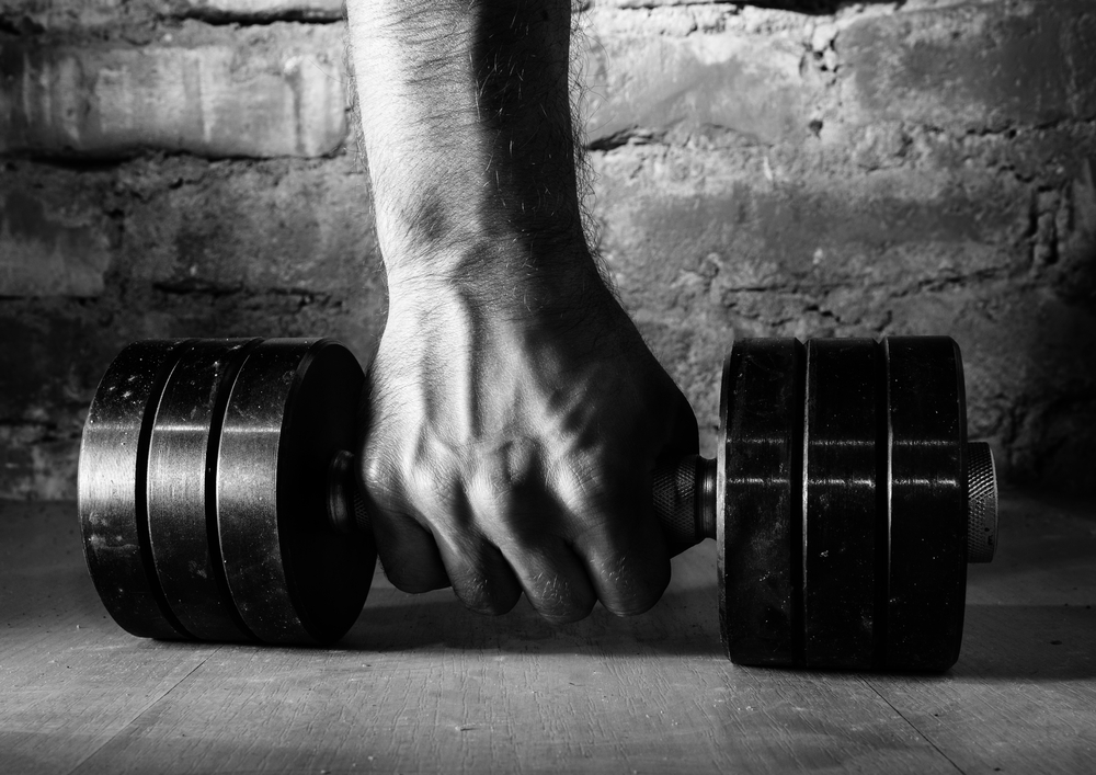 male hand is holding metal barbell