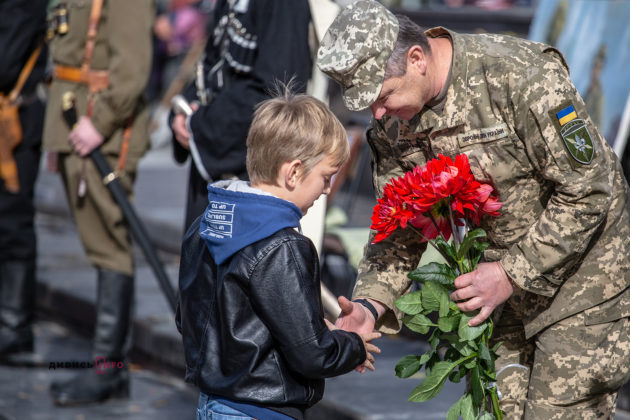 хлопчик тисне руку військовому під час маршу у Львові.