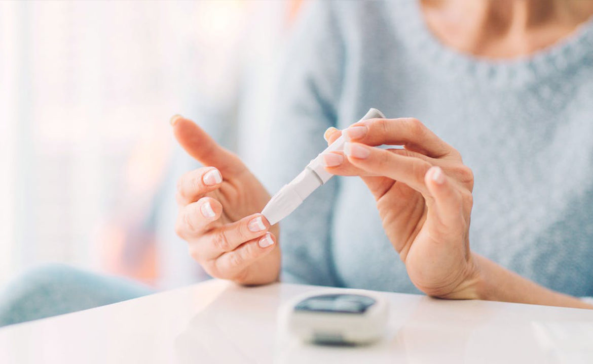 жінка з діабетом вимирює рівень цукру в крові спеціальною тест-смужкою